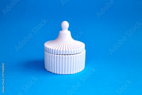 White ceramic trinket box isolated on blue background 