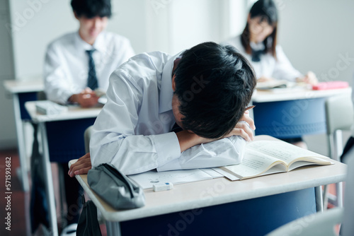 教室で授業中居眠りをする男子高校生