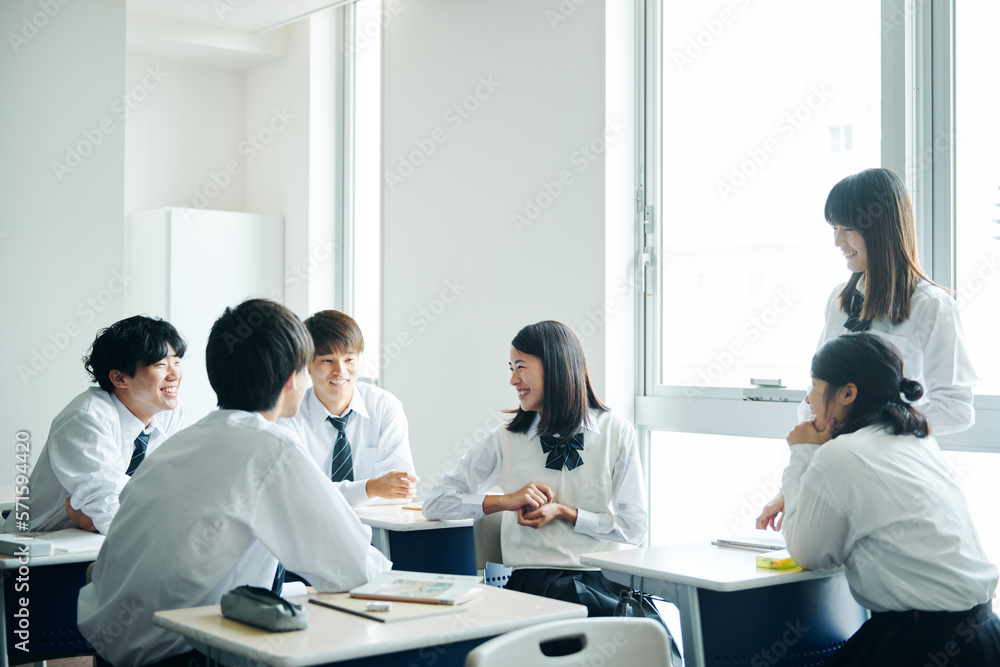 休み時間に教室で雑談する高校生 休み時間に教室で雑談する高校生