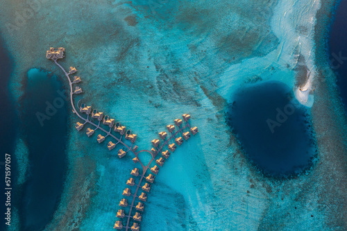 Aerial view of a luxury resort with bungalow on a small island in the Laccadive Sea at night, Indian Ocean, Maldives archipelagos.