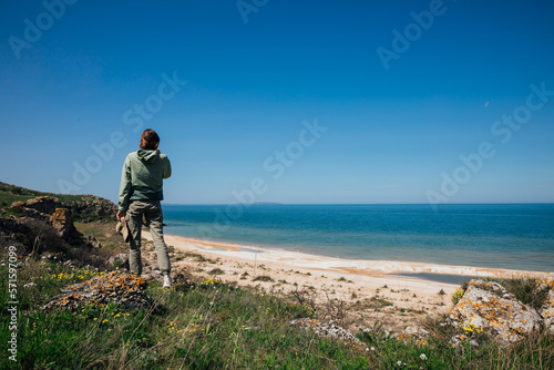 a person standing near the sea beach looks into the distance travel hiking
