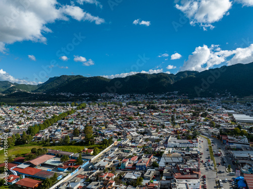 Aerial view of colorful mountain village of San Cristobal de Las Casas in Mexico. Clouds over the mountains. Panorama. © nikwaller