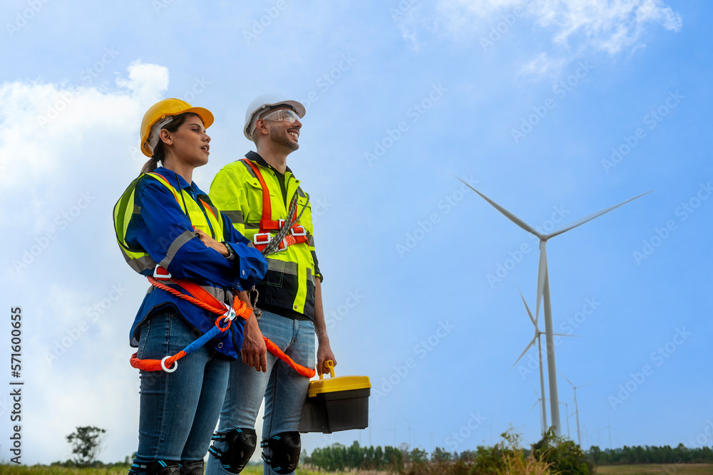 two engineers and a young man and a woman in a blue shirt and a white helmet and a wind two engineers and a young man and a woman in a blue shirt and a white helmet and a wind