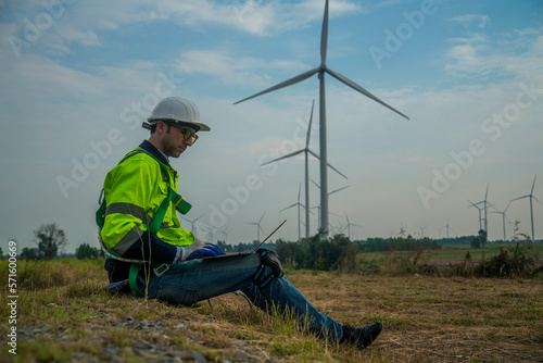 engineer using tablet and power plant, wind turbine, energy protection, alternative environment