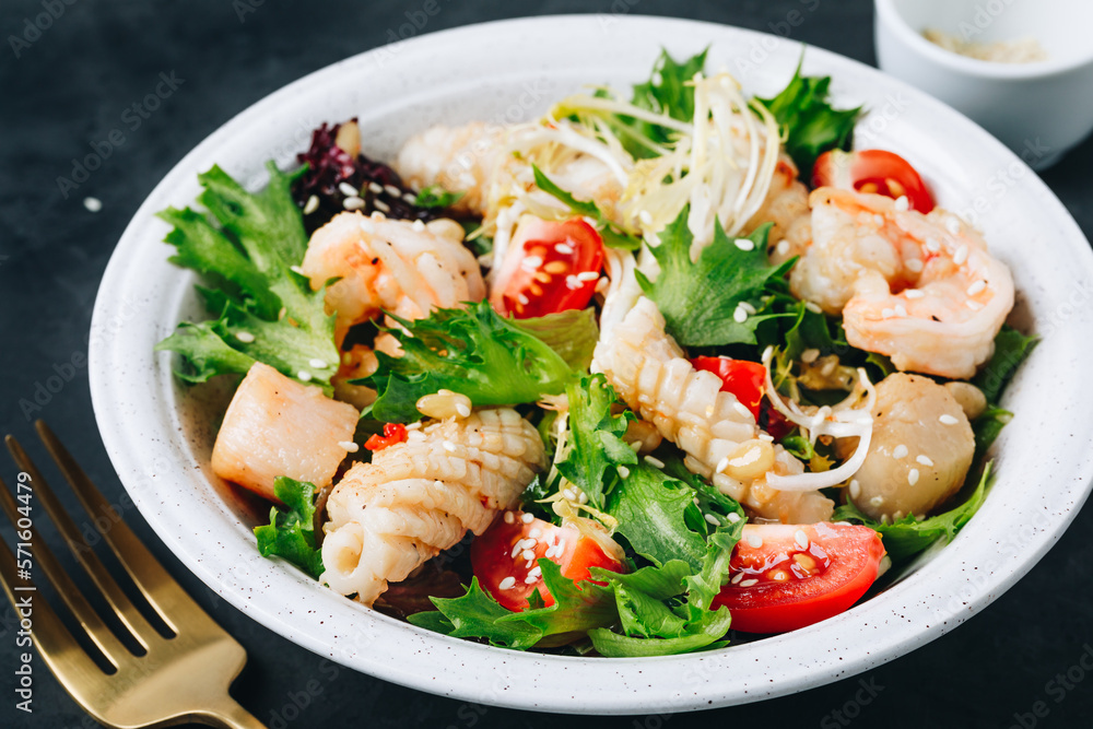 Seafood salad bowl. Green lettuce tomato salad with shrimps, scallop and squids Seafood salad bowl. Green lettuce tomato salad with shrimps, scallop and squids