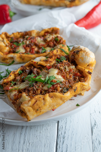 Turkish pide with minced meat, vegetables and cheese