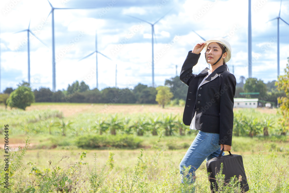 Young Asian businesswoman in suit with electric turbine as background Young Asian businesswoman in suit with electric turbine as background