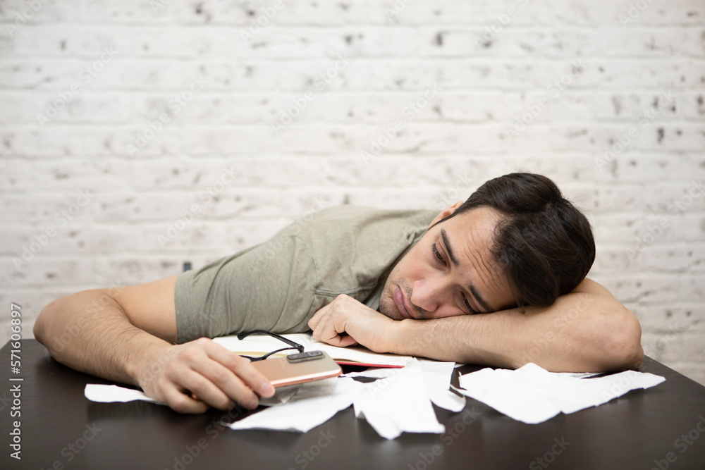 Close up of unhappy man sitting at the table, stressed and confused by calculate expense from invoice or bills, have no money to pay mortgage or loan. High prices and spending money concept Close up of unhappy man sitting at the table, stressed and confused by calculate expense from invoice or bills, have no money to pay mortgage or loan. High prices and spending money concept