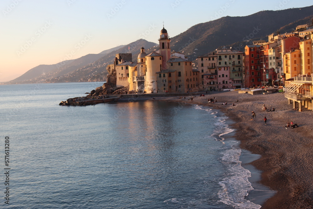 Camogli, Italy - January 27, 2023: Beautiful old mediterranean town at the sunrise time with illumination during winter days.
People enjoying the evening at the beach with beautiful sunset background