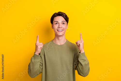 Photo of nice positive person look direct fingers empty space isolated on yellow background