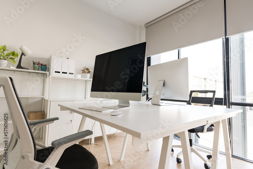 Fototapeta Naklejka Na Ścianę i Meble -  White table and chair with computer monitor and modern file cabinet in white home office