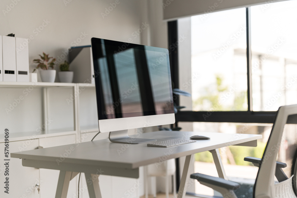 White table and chair with computer monitor and modern file cabinet in white home office White table and chair with computer monitor and modern file cabinet in white home office