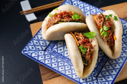 Food concept Homemade organic Pulled Beef Bao Buns or Gua Bao in sqare plate on black background with copy space