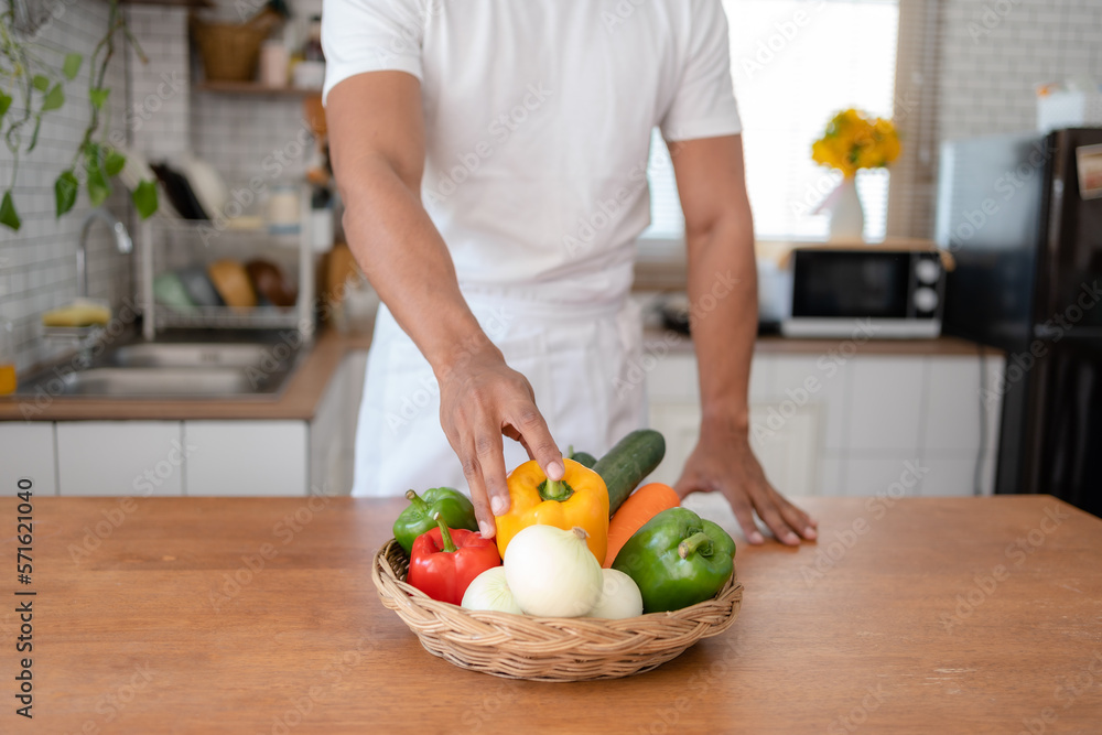 Man holding bell pepper preparing food in kitchen at home. Man holding bell pepper preparing food in kitchen at home.