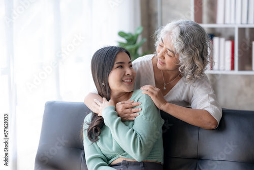 Asian mother and son spending vacation in living room Show your love for each other by embracing each other warmly and happily at home.