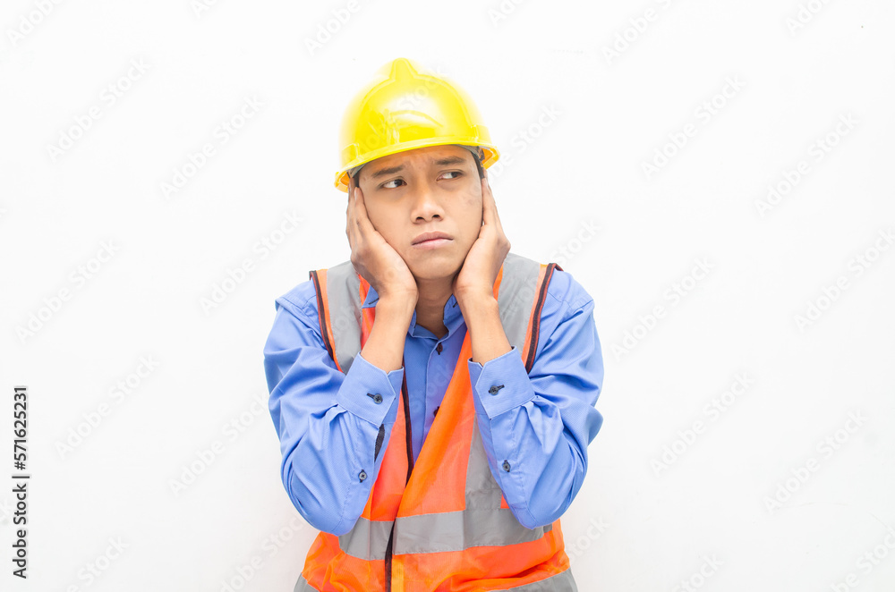 stressed over work concept illustrated by asian male construction worker in blue shirt, orange vest and yellow safety helmet with furious, mad, sad, angry expression. overworked concept