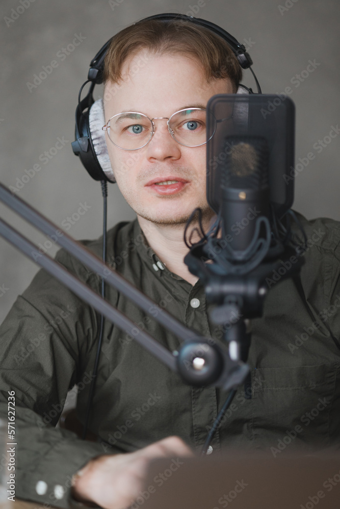 portrait of man in studio is recording podcast, audio content of interview on radio. Caucasian male speaks into microphone for voice recording or advertising. working online on internet, discussing portrait of man in studio is recording podcast, audio content of interview on radio. Caucasian male speaks into microphone for voice recording or advertising. working online on internet, discussing