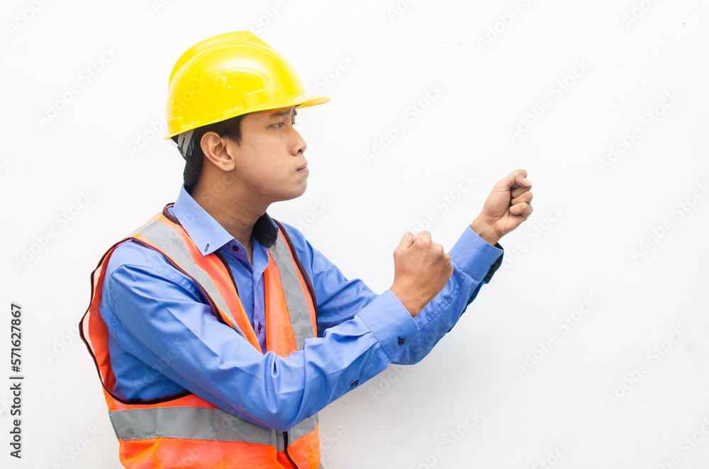 side view of stressed over work concept illustrated by asian male construction worker in blue shirt, orange vest and yellow safety helmet with furious, mad, sad, angry expression. overworked concept side view of stressed over work concept illustrated by asian male construction worker in blue shirt, orange vest and yellow safety helmet with furious, mad, sad, angry expression. overworked concept