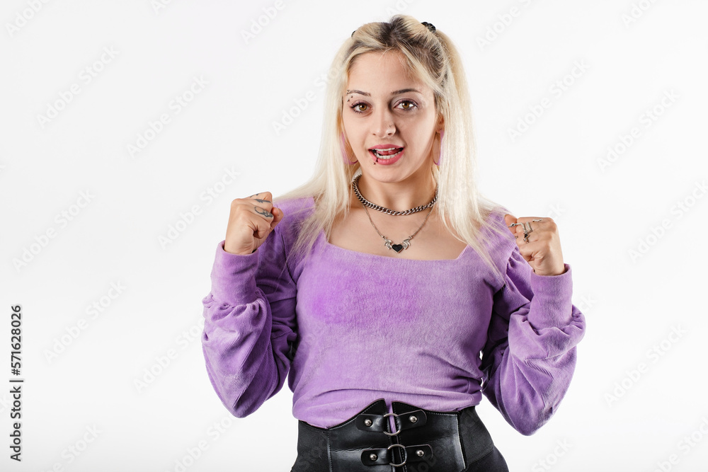 Happy woman wearing ribbed blouse standing isolated over white background rejoicing, say yes, looking happy and celebrating victory, champion dance, fist bump gesture. Finally, hooray! Happy woman wearing ribbed blouse standing isolated over white background rejoicing, say yes, looking happy and celebrating victory, champion dance, fist bump gesture. Finally, hooray!