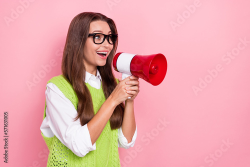 Photo of young activist happy screaming loud bullhorn announcement look curious empty space new advert isolated on pastel pink color background