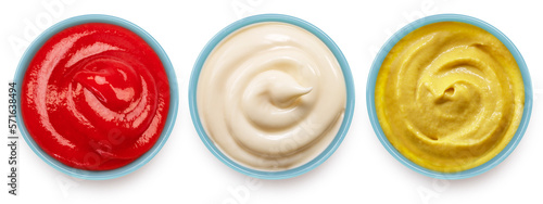 Ketchup, mustard and mayonnaise sauces on ceramic blue bowl on white background. File contains clipping path.