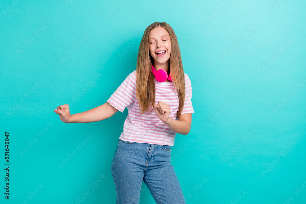 Photo of overjoyed positive girl closed eyes enjoy dancing chilling isolated on teal color background Photo of overjoyed positive girl closed eyes enjoy dancing chilling isolated on teal color background