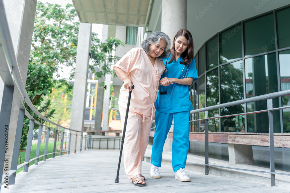 Asian woman doctor shook hands, encouraged and supported elderly woman patient, Which holds a cane for help support to walking. to  health insurance and osteoarthritis concept.