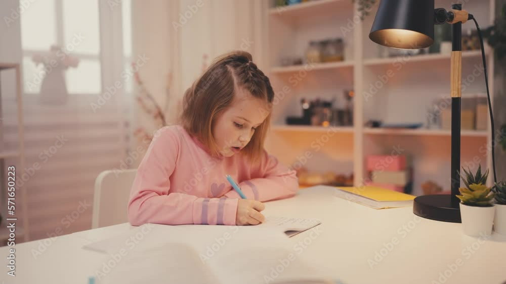 Focused little girl doing homework alone, home schooling, getting knowledge Focused little girl doing homework alone, home schooling, getting knowledge