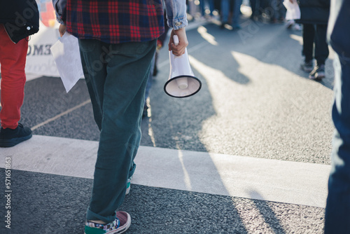 Valokuva Teenage girl walking holding megaphone in her hands at a demonstration