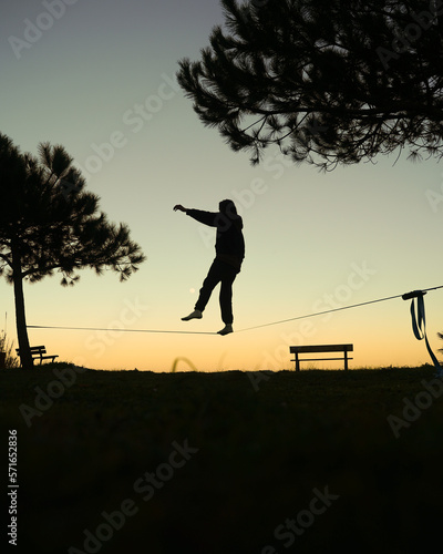 Silhouette of man on a slackline, equilibrium sport, slacklining activity