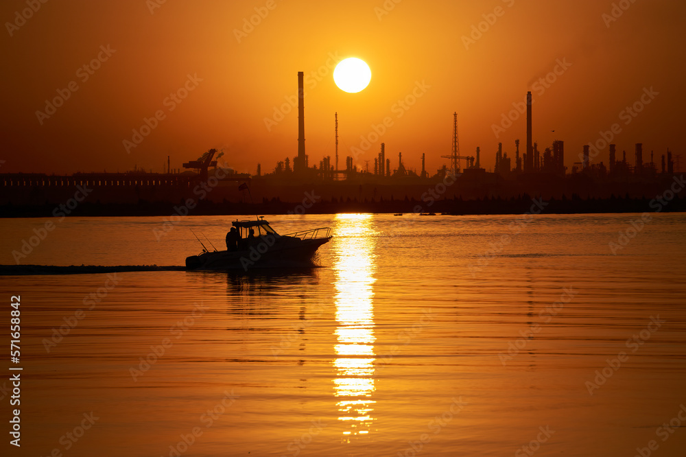 sunrise with orange sky and fishing boat