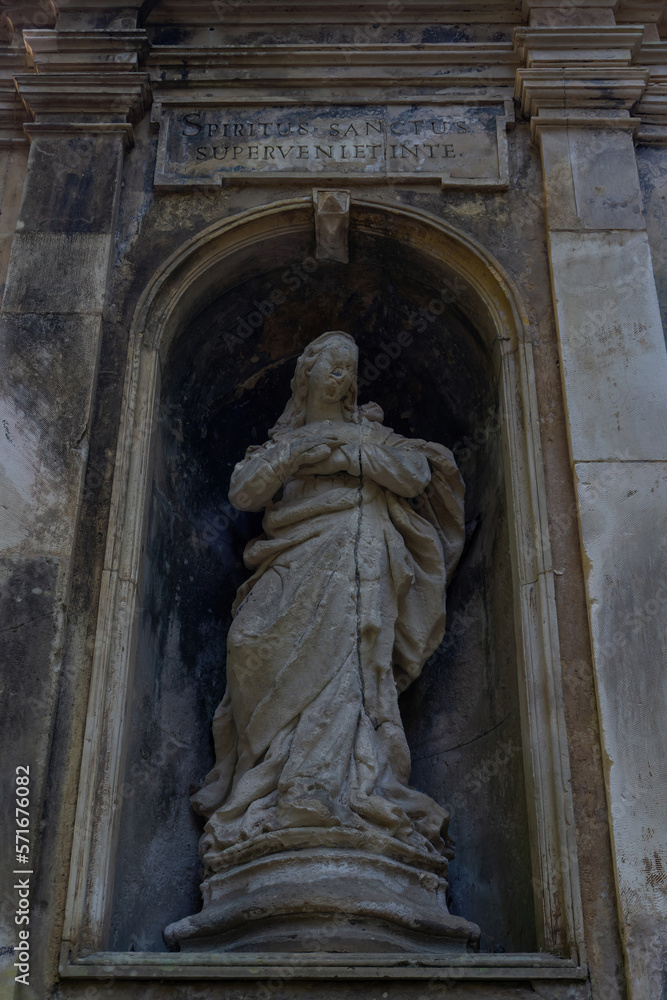 A ancient statue in a niche with an inscription in Latin 