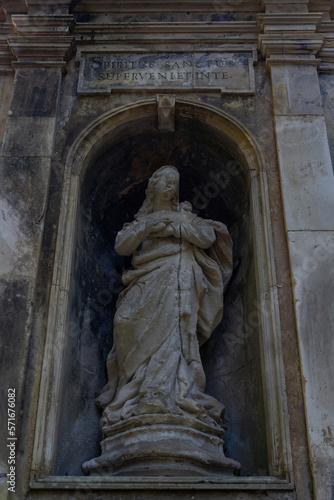 A ancient statue in a niche with an inscription in Latin "The coming of the Holy Spirit"