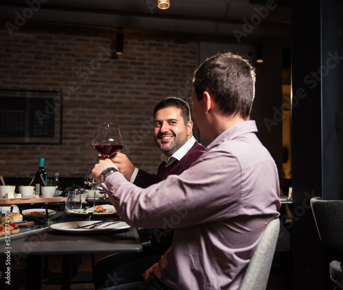 Group of friends toasting with wine in restaurant