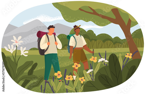 Couple travelers with backpacks and hiking stick walking together. Outdoor travelling and nature camping. Tourists on trip stand on green lawn. Tracking through mountains and trails, adventure time