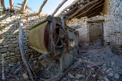Old Winnower. Aventadora. Old agricultural machinery from the early XX century. Manual agricultural machinery. Abandoned house. Abandonde village photo