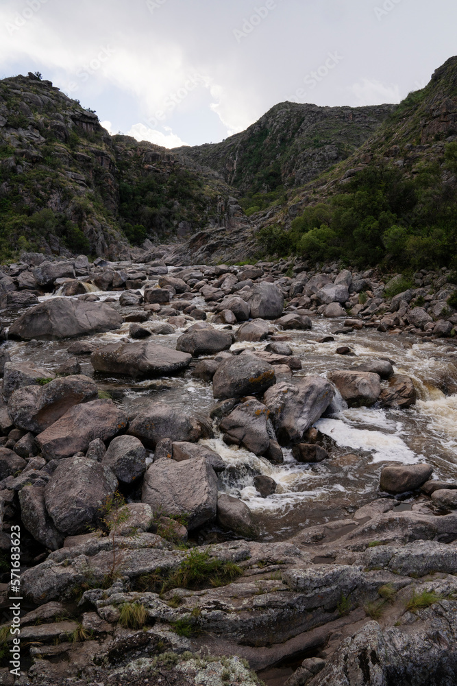 View of the river Yuspe in The Giants natural reserve in Cordoba, Argentina. View of the water flowing across the rocks and forest.