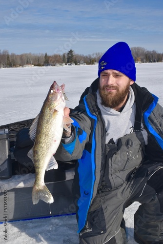 An ice angler with a walleye 
