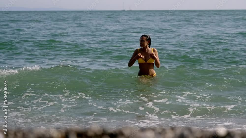 beautiful young woman in bikini coming out of sea water beautiful young woman in bikini coming out of sea water