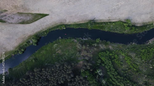 People on the river. People floating on a boat. A boat is floating on the river. The river from a bird's eye view. Landscape reservoir, forest and fields. Ice on the water. 