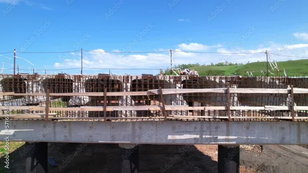 Construction of a road bridge. Aerial shot. Visual view of the connection between concrete beams and iron reinforcements. Construction of reinforced concrete structures. Road construction. Construction of a road bridge. Aerial shot. Visual view of the connection between concrete beams and iron reinforcements. Construction of reinforced concrete structures. Road construction.