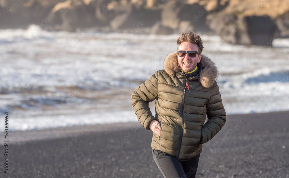 Caucasian smiling and runing towards the camera on Renisfjare beach, Iceland