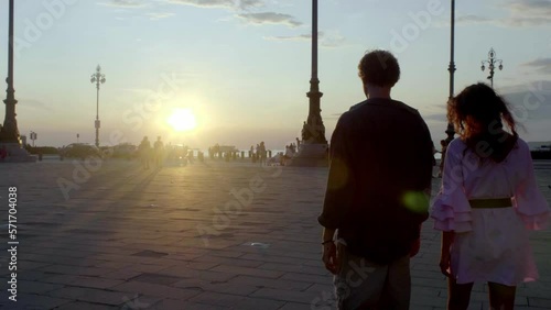 young couple enjoing sunset together in piazza unità in trieste photo