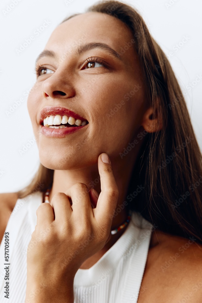 Portrait of a young beautiful woman with tanned skin model on a white background in a white T-shirt with a chain around her neck Portrait of a young beautiful woman with tanned skin model on a white background in a white T-shirt with a chain around her neck