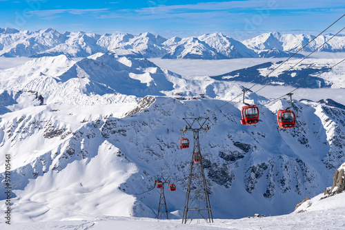 Red gondolas of cable car seen from Bellecote glacier, La Plagne ski resort, France,  in winter. Inversion clouds in valley © hopsalka
