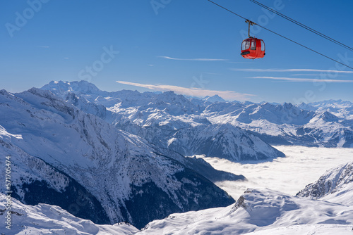 Red gondola of cable car seen from Bellecote glacier, La Plagne ski resort, France,  in winter. Inversion clouds in valley © hopsalka