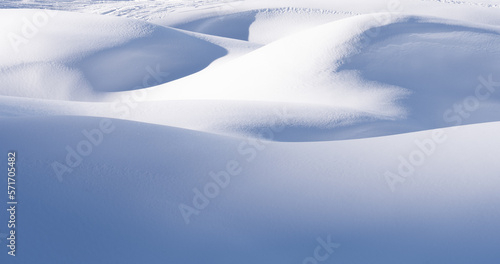 Snow mounds and snowdrifts on sunny winter day. Abstract snowy background
