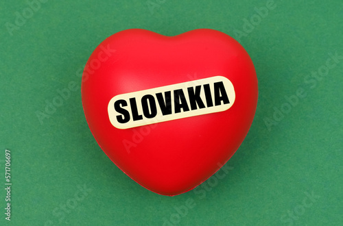 On a green surface lies a red heart with the inscription - Slovakia
