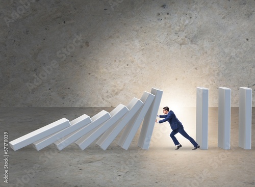 Fotografía Businessman preventing domino effect in business concept