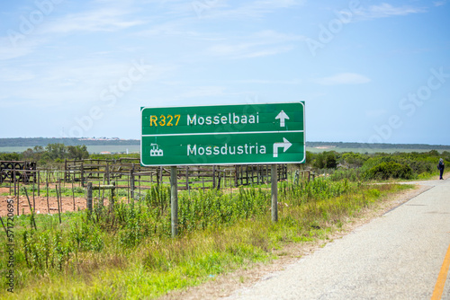 Western Cape, South Africa - December 23rd, 2022: A direction sign on R327 road, between towns of Herbertsdale and Mossel Bay, pointing to Mossdustria, an industrial Neighborhood of Mossel Bay.
